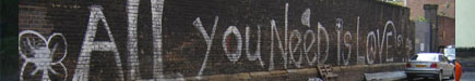 All you need is love text on a brick wall