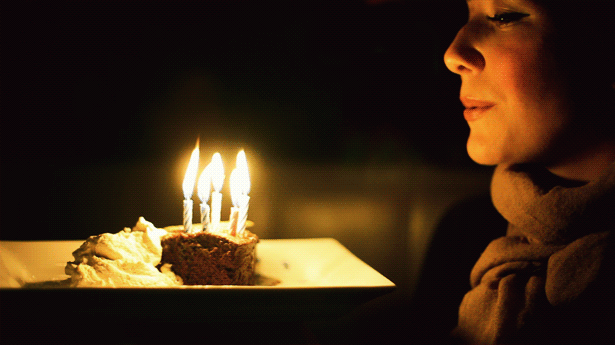Girl blowing candles on a Birthday cake